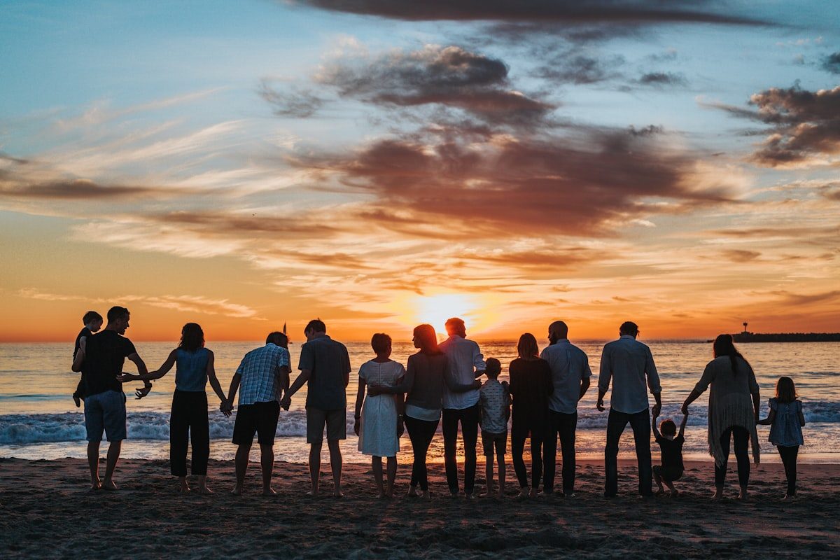 Three generations of a family together on the beach at sunset